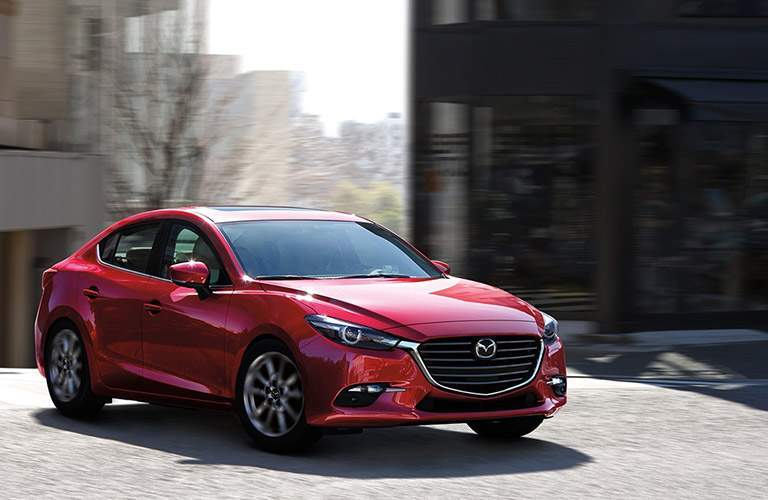 red mazda3 four door parked