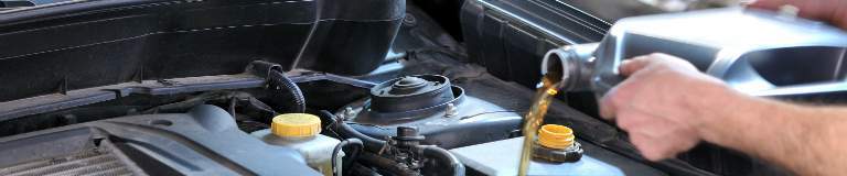 man filling car with oil