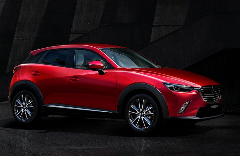 side view of red 2018 mazda cx-3 against black background
