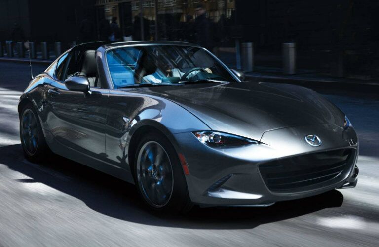 man driving dark gray mazda mx-5 miata