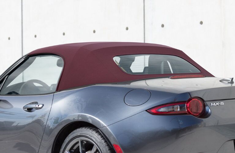 gray mazda miata with maroon soft top