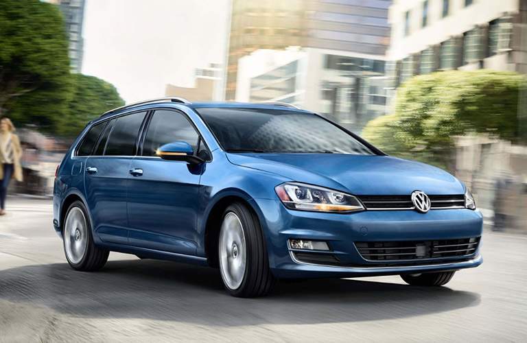 blue volkswagen golf sportwagen driving in city