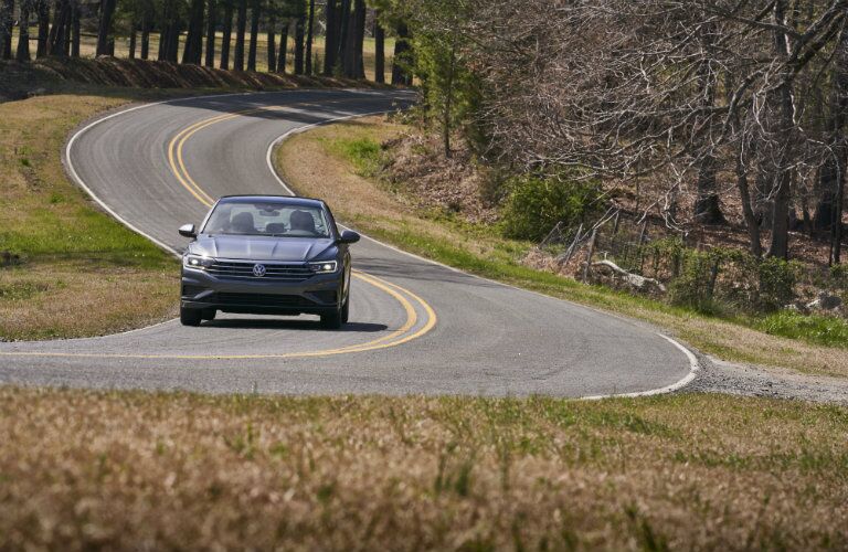 gray volkswagen jetta on winding rural road