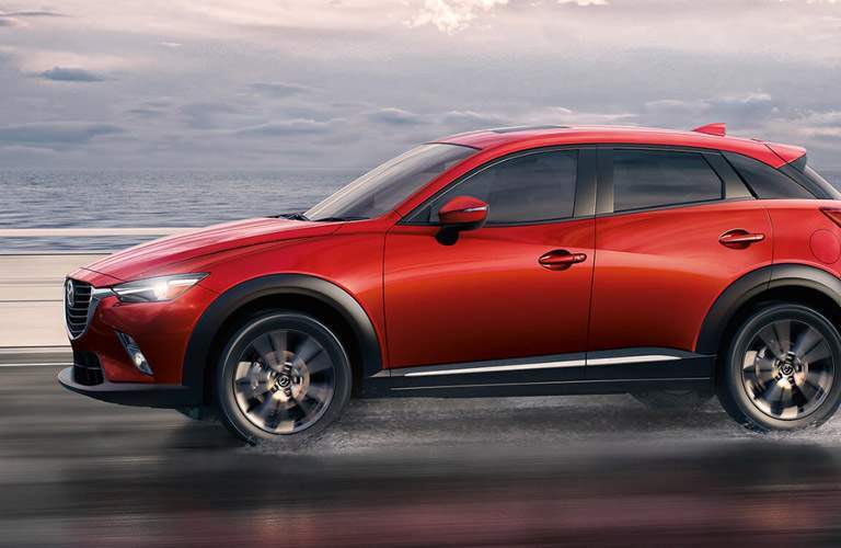 Side View of the 2017 Mazda CX-3 in Red with Headlights Illuminated