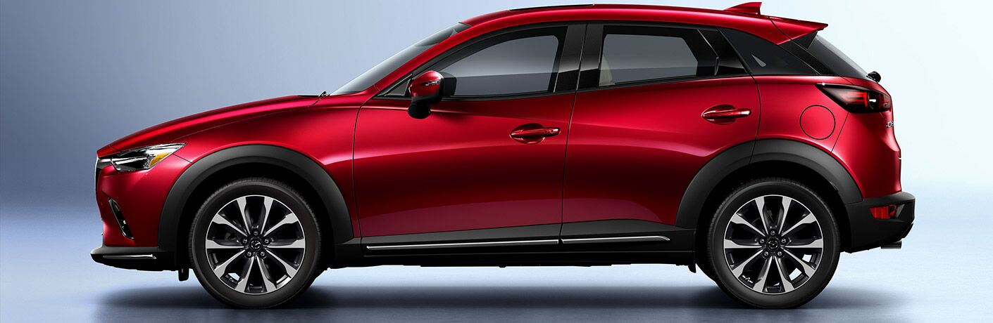 Profile view of red 2019 Mazda CX-3 on silver background