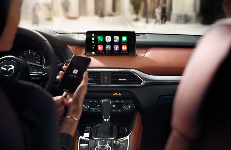 A photo of someone connecting a smartphone into the 2019 Mazda CX-3 Touring.