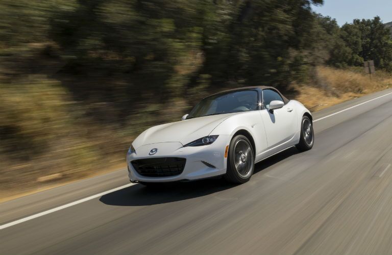 A front-left quarter photo of the 2019 Mazda MX-5 Miata in motion on the road.