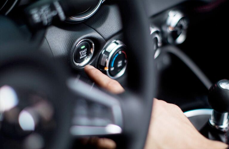 Closeup of hand pushing start button in 2019 Mazda MX-5 Miata RF