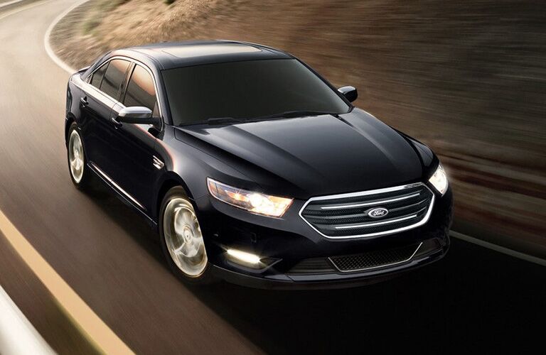 2018 Ford Taurus in black driving on a road