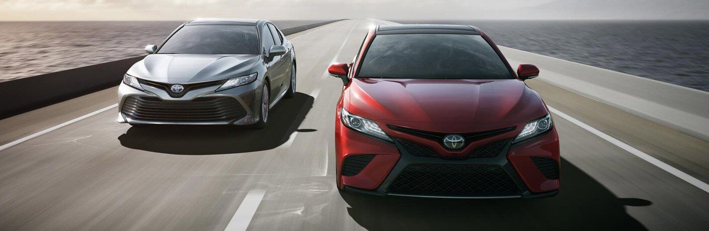 Two 2018 Toyota Camry Models in White and Red Front End View