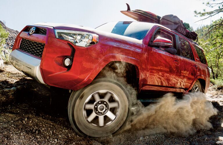 2019 Toyota 4Runner in red kicking up dirt on a trail