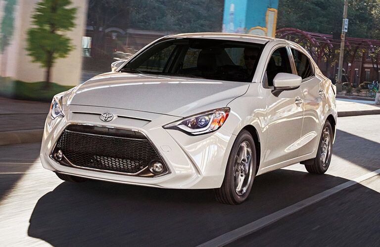 2019 Toyota Yaris Sedan Driving Down Road in White Coloring