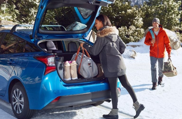 woman and man loading cargo into rear of 2019 Toyota Prius