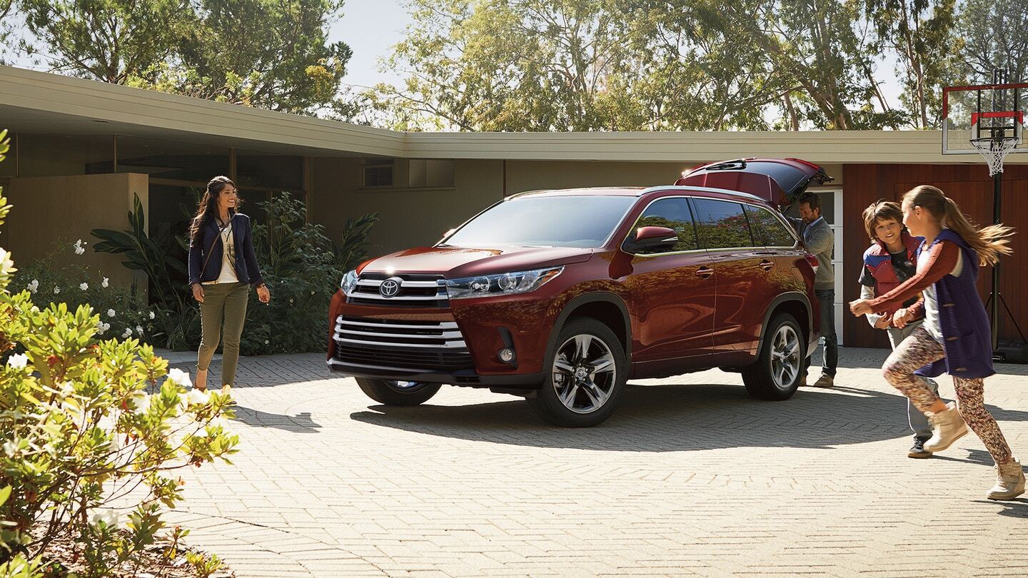 Driver side exterior view of a red Toyota Highlander
