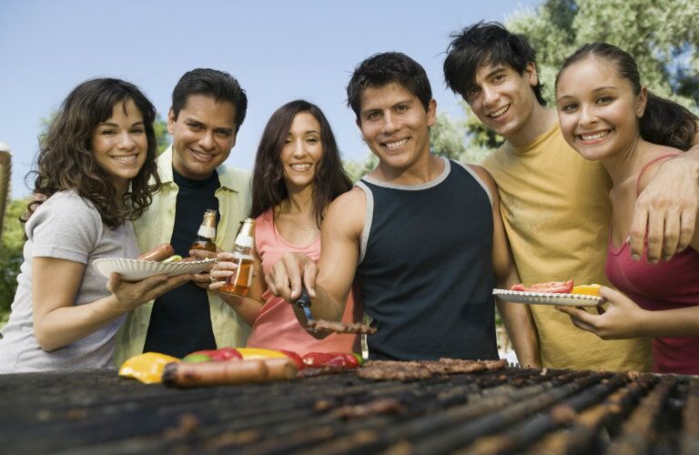 a happy group of people eating food from a food truck