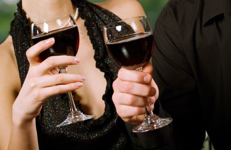 upper torso shot of a man and woman holding wine