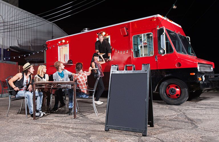 people eating from a red food truck