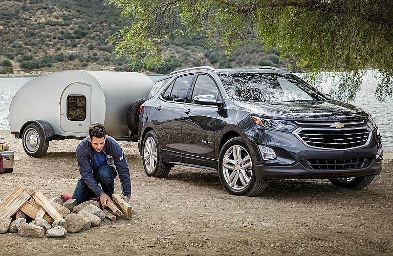 2018 Chevy Equinox black towing a small camper