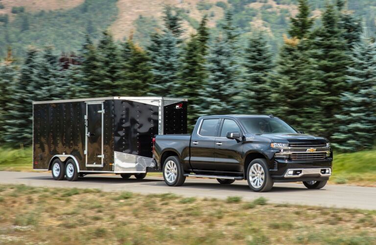 2019 Chevy Silverado 1500 black side view with a trailer