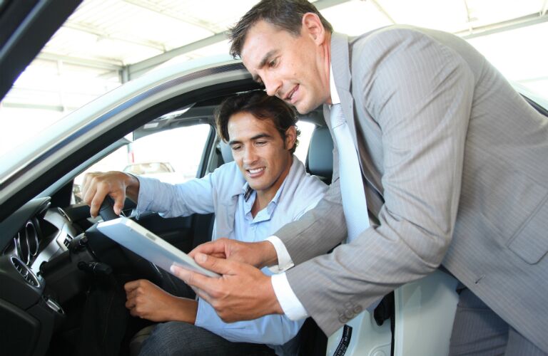 salesman helping a customer in a car