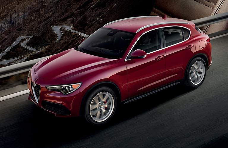 Red Alfa Romeo Stelvio driving on winding road