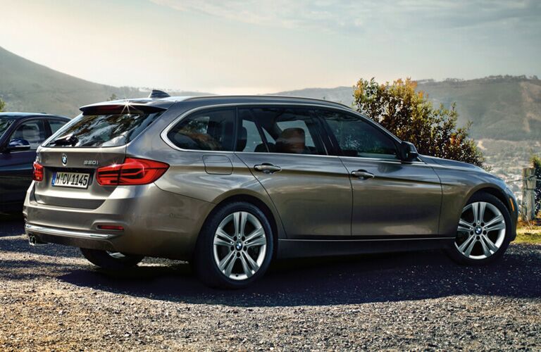 Pewter BMW 3-Series wagon parked in front of mountainous formation