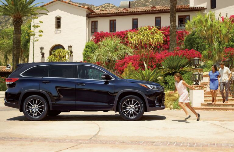 2017 Toyota Highlander Parked Outside a House with Family Walking Towards the Vehicle
