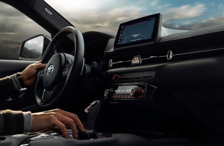 A photo of a person using the infotainment system in the 2020 Toyota Supra.