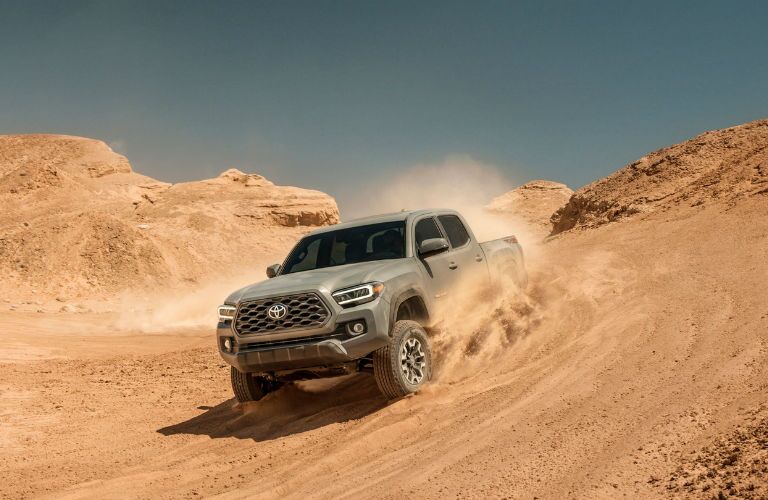 A photo of a 2020 Toyota Tacoma TRD-branded truck coming down a desert hill.