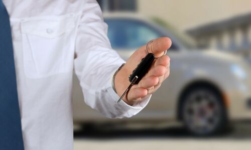 Man handing over the keys to his trade-in vehicle at a dealership