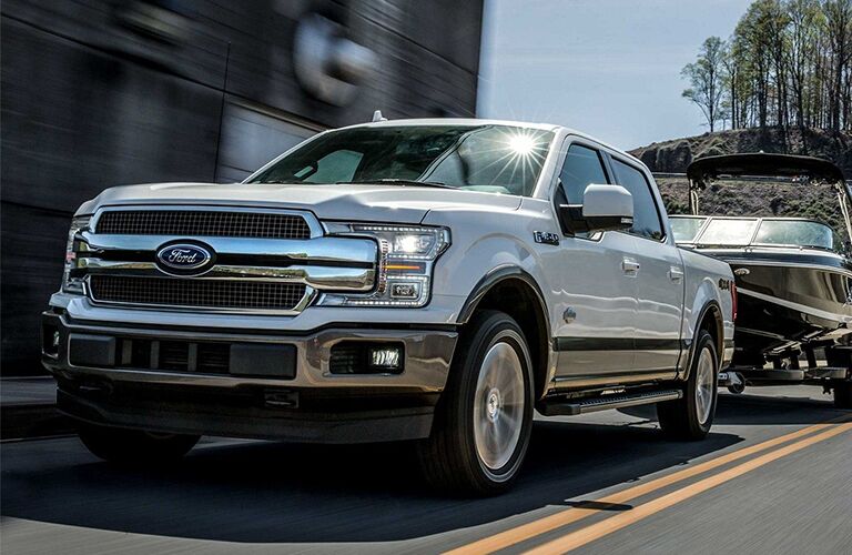 white 2019 Ford F-150 towing a boat