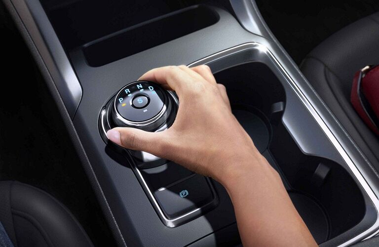 Closeup of hand on rotary dial gear shift in 2019 Ford Fusion