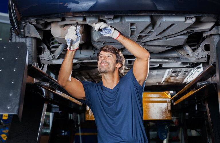 Mechanic working on the undercarriage of a vehicle