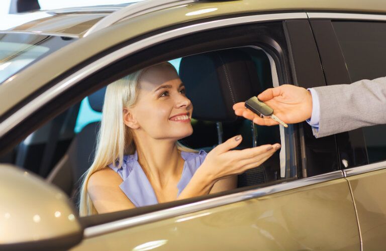 Woman receiving the keys to her new vehicle