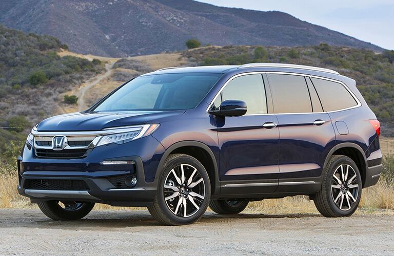 Driver side exterior view of a blue Honda Pilot