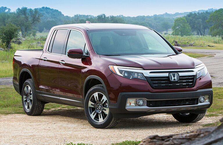 Front passenger side exterior view of a red Honda Ridgeline