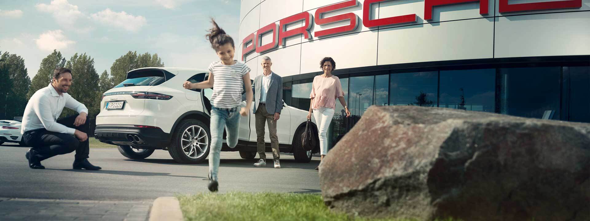 A family in front of Dealersocket Porsche in Oshkosh, WI