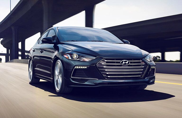dark hyundai elantra under bridge on road