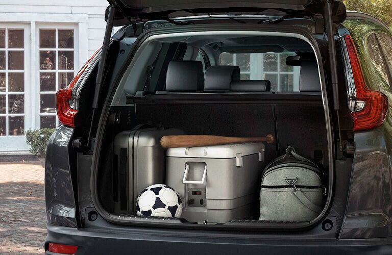 2021 Honda CR-V exterior rear shot of open trunk loaded with luggage, a soccer ball, and a baseball bat