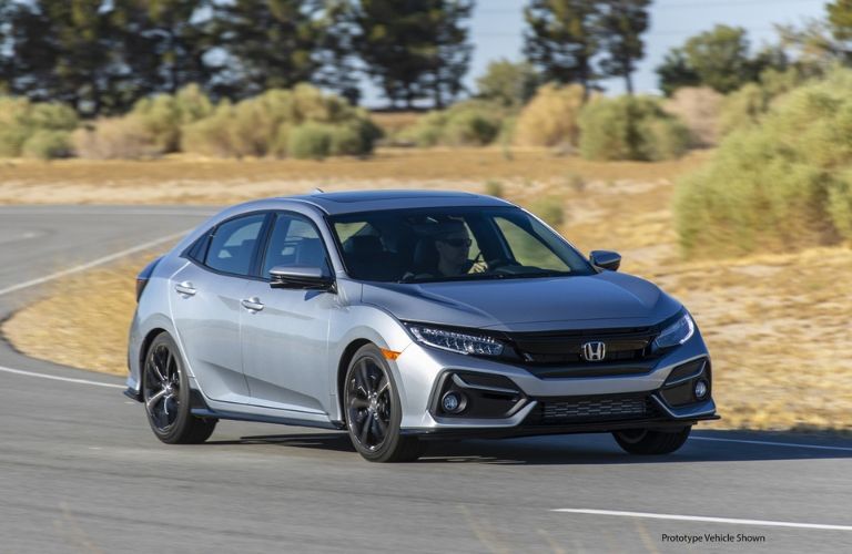 Silver 2020 Honda Civic Hatchback Front Exterior in Desert with Black Prototype Vehicle Shown Text in Lower Right Corner