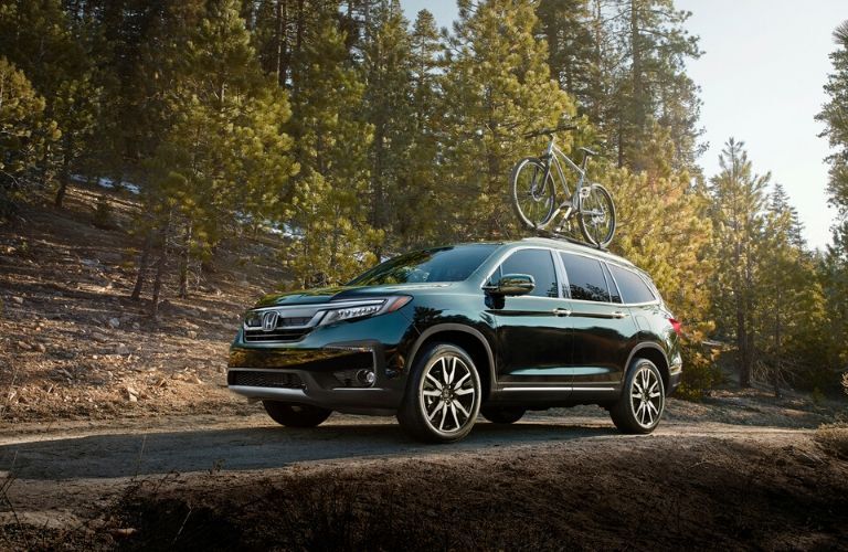 Green 2020 Honda Pilot on a Forest Trail