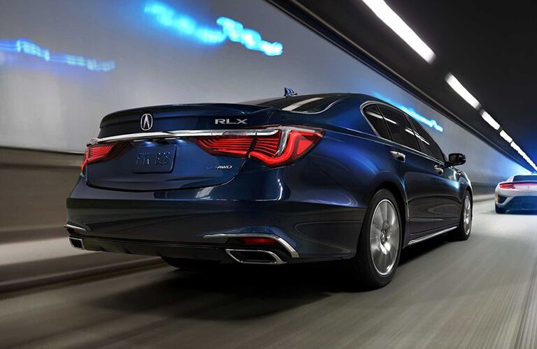 Rear shot of blue 2019 Acura RLX driving through tunnel