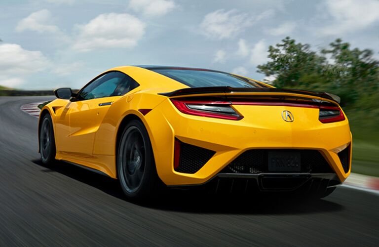 Driver's side rear angle view of yellow 2020 Acura NSX