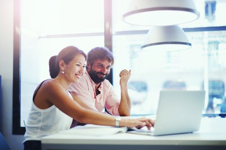 A man and a woman working on a computer together