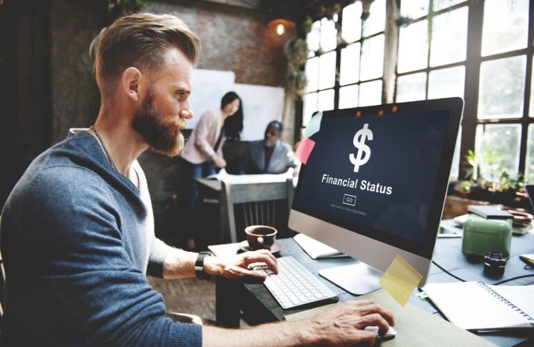 Man sitting at computer with "financial status" on the screen
