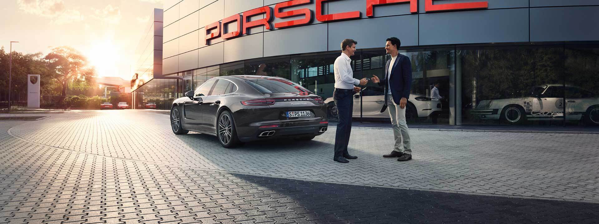 Two people exchanging keys to a Porsche in Highland Park, IL
