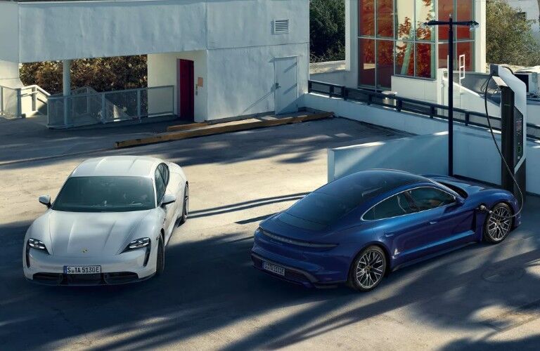 Two 2020 Porsche Taycan models at charging station
