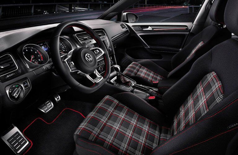 Interior front region with checkered seats inside a 2017 Volkswagen Golf GTI.