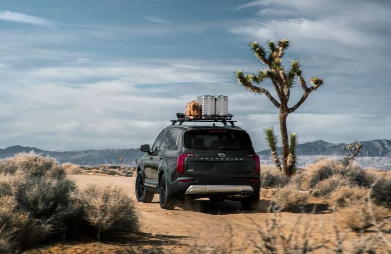 A rear photo of the 2020 Kia Telluride outfitted with a roof rack and parked in the desert.