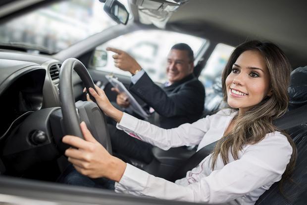 happy woman in car with salesman